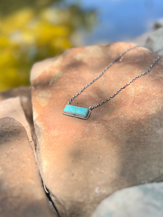 Necklace with a turquoise pendant on a rock