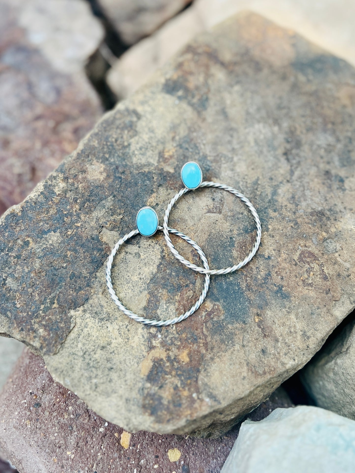 Two turquoise beaded bracelets on a textured stone surface