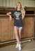 Woman wearing a black t-shirt with a graphic design, standing in a barn.