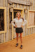 Woman standing in front of a rustic wooden building with 'Western Signs' sign.
