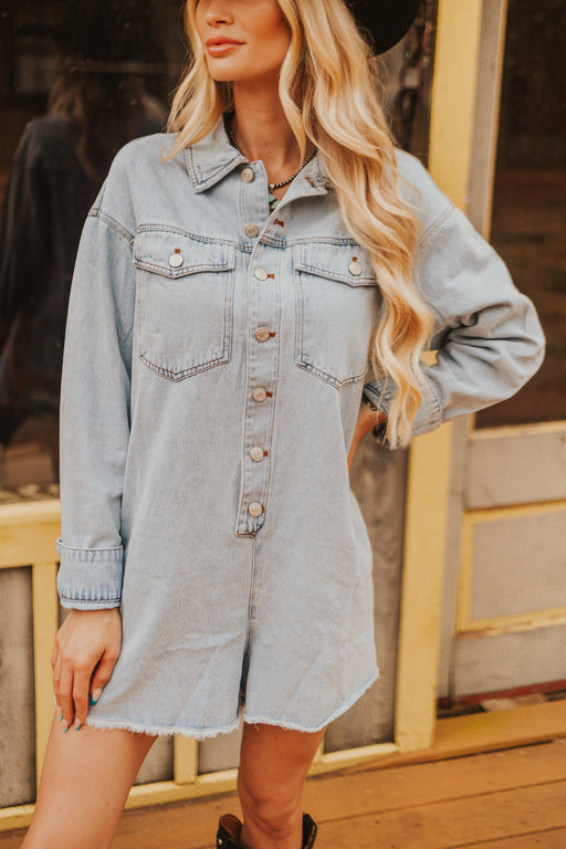 Woman wearing a light blue denim dress with a blurred background