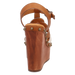 Brown wedge sandal with strap and decorative studs on a white background