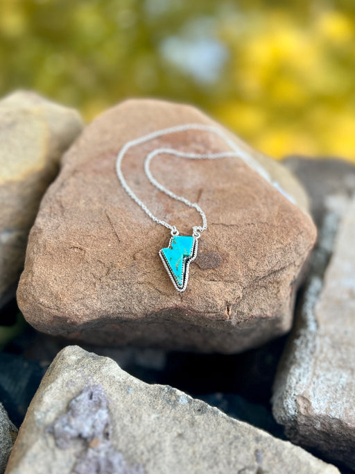 Necklace with a blue pendant on a rock