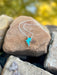 Necklace with a blue pendant on a rock