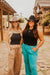 Two women wearing cowboy hats and casual outfits standing outdoors.