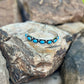 Silver bracelet with blue stones on a rock