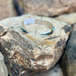 Silverbracelet with a blue stone on a rough stone surface