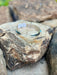 Silverbracelet with a blue stone on a rough stone surface