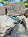 Silver bracelet with turquoise stones on a rock background