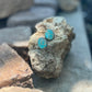 Turquoise stone earrings on a rock with a natural background