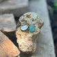 Two earrings displaying the 425 silver stamp on a rock with a natural background