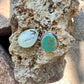 Turquoise stone and silver earring on a rock