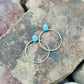 Two turquoise beaded bracelets on a textured stone surface