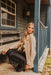 Woman sitting on a wooden porch with a rustic cabin background