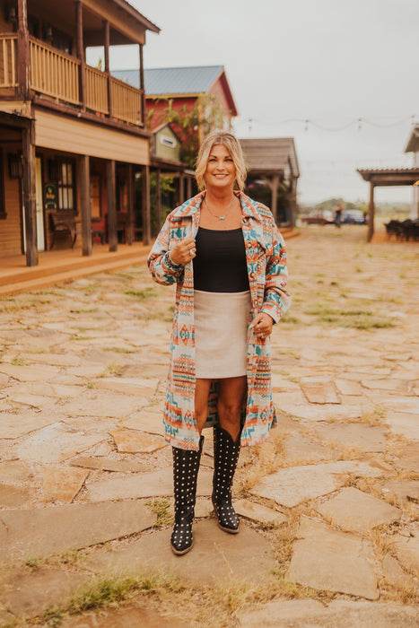 Woman standing on a stone path in front of wooden buildings