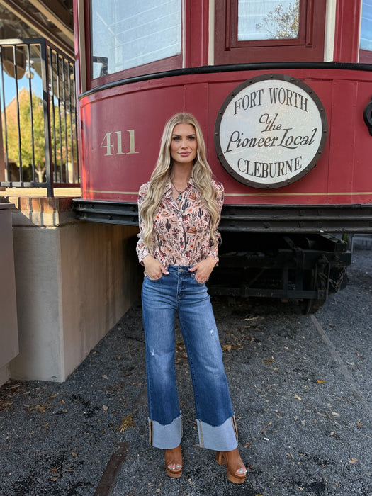 Woman standing in front of a red trolley with 'Fort Worth The Pioneer Local Cleburne' sign.