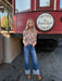 Woman standing in front of a red trolley with 'Fort Worth The Pioneer Local Cleburne' sign.